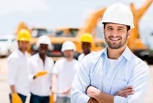 A Contractor stands in front of construction equipment